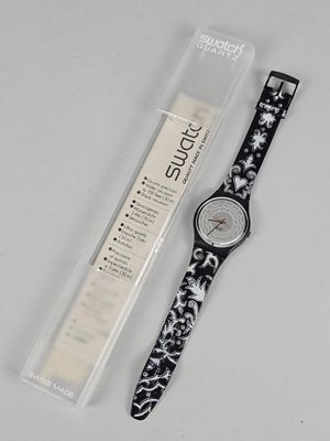 the watch is black and white with a floral pattern on it