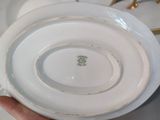 a person holding a white plate with a green design on it