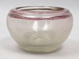 a glass vase with a pink rim sitting on a white surface