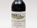 une bouteille de vin rouge posée sur une table blanche