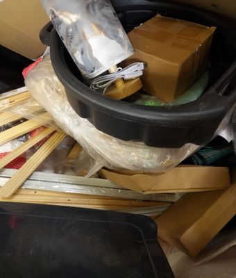 a bucket full of items sitting on the floor next to boxes