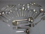 de nombreuses cuillères et fourchettes disposées en cercle sur la table