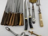 many different types of knives and spoons on the table