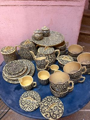 une assiette bleue sur laquelle sont posés plusieurs tasses et soucoupes