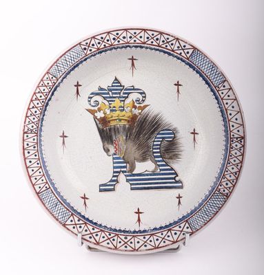 une assiette sur laquelle sont représentés un oiseau et une couronne