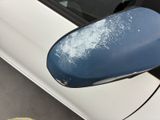 a blue mirror on the side of a white car