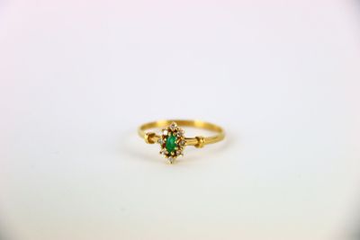 a close up of a gold ring with a green stone