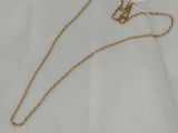 a gold necklace with a chain on a white background