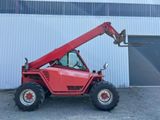 a picture of a red forklift truck parked in front of a building