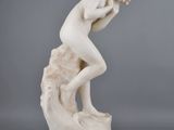 a white marble statue of a man on a rock with his head in his hands