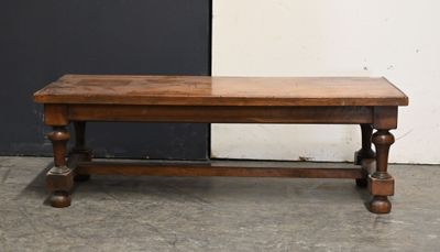 a wooden bench sitting in front of a black and white wall