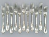 six fourchettes et six couteaux sont disposés en rangée sur une table