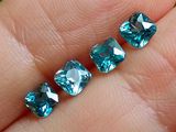 une personne tenant une paire de diamants bleus dans la main