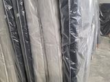 une pile de matelas emballés dans du plastique dans un entrepôt