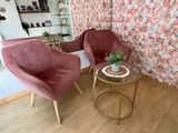 two chairs and a table in a room with a floral wallpaper