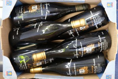 six bouteilles de vin dans un carton sur une table