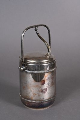 a small silver container with a handle on a table