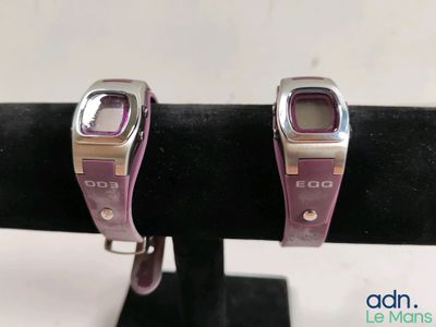 pair of silver and purple watches on display on a black stand