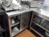 une cuisine avec de nombreux plans de travail en inox
