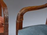 pair of carved wood chairs with blue velvet upholstered cushions