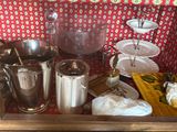 Plusieurs casseroles et poêles sont posées sur une table, à côté d'assiettes et de couverts.