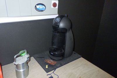 une cafetière posée sur une table à côté d'une tasse