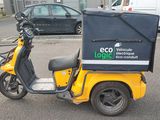 a yellow scooter with a box on the back of it