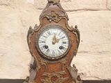 une horloge posée sur une table devant un mur de briques