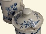 two blue and white jars with lids on a white surface