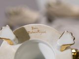 a white and gold plate with a gold decoration on it
