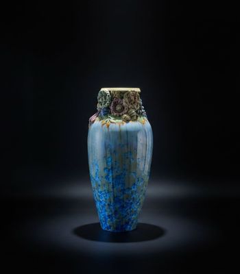un vase bleu posé sur une surface noire