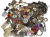 a pile of assorted jewelry on a white surface
