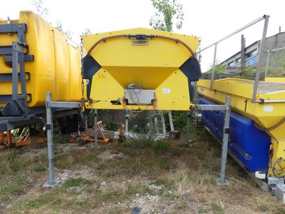 a yellow and blue truck parked next to a yellow and black truck