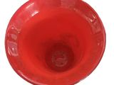 a red bowl that is sitting on a white surface