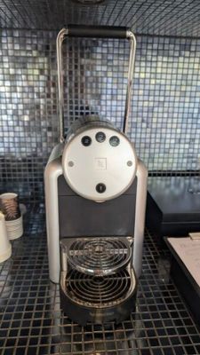 une machine à café posée sur un sol carrelé