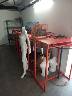 un mannequin debout à côté d'une table dans une pièce
