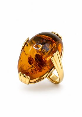 un gros plan d'une bague sertie d'une grosse pierre d'ambre