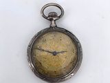 an antique pocket watch with a gold dial on a white background