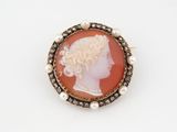 Une broche représente le profil d'une femme.