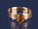 une bague ornée d'une pierre jaune sur un fond bleu