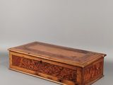 une vieille boîte en bois posée sur une surface grise