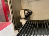 une machine qui découpe des barres métalliques sur un tapis roulant