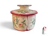 a white and red jar with flowers on it