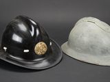pair of fireman ' s helmets on a black background