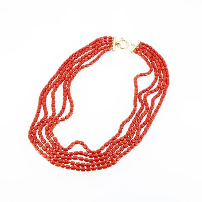 gros plan d'un collier de perles rouges sur fond blanc