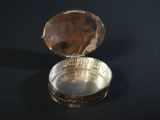 a small silver box with a coin inside of it