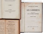 plusieurs livres sont empilés sur une surface blanche