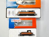 trois trains miniatures dans leurs boîtes, empilés les uns sur les autres sur une table