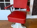 an image of a red and white barber chair in front of a door