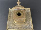 brass plate with a clock on top of it on a black surface
